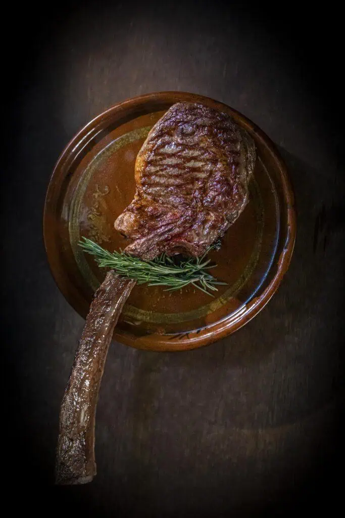 Côtelette d'agneau juteuse grillée au romarin sur la terrasse ou sur un fond en bois.