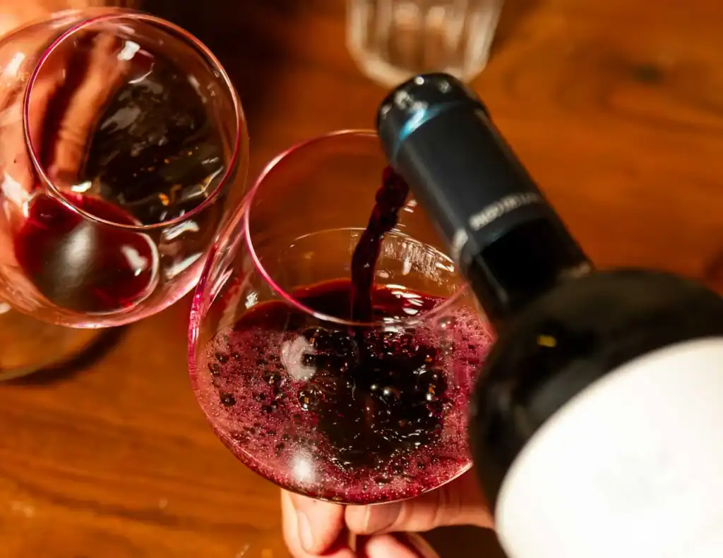 Geniet van een glas rode wijn bij Las Mañas, een sfeervol restaurant in Antwerpen dat bekend staat om zijn uitstekende wijnselectie en Mediterrane gerechten.
