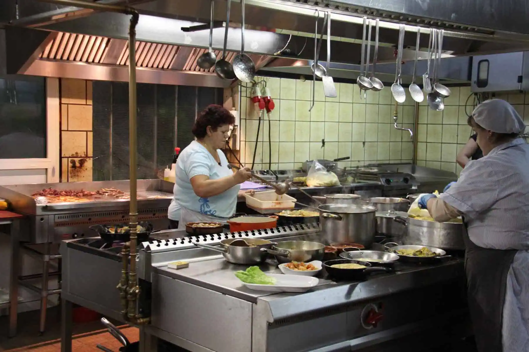 Gezellige restaurantkeuken met ervaren koks die authentieke Spaanse specialiteiten koken in een warme sfeer bij Las Mañas.