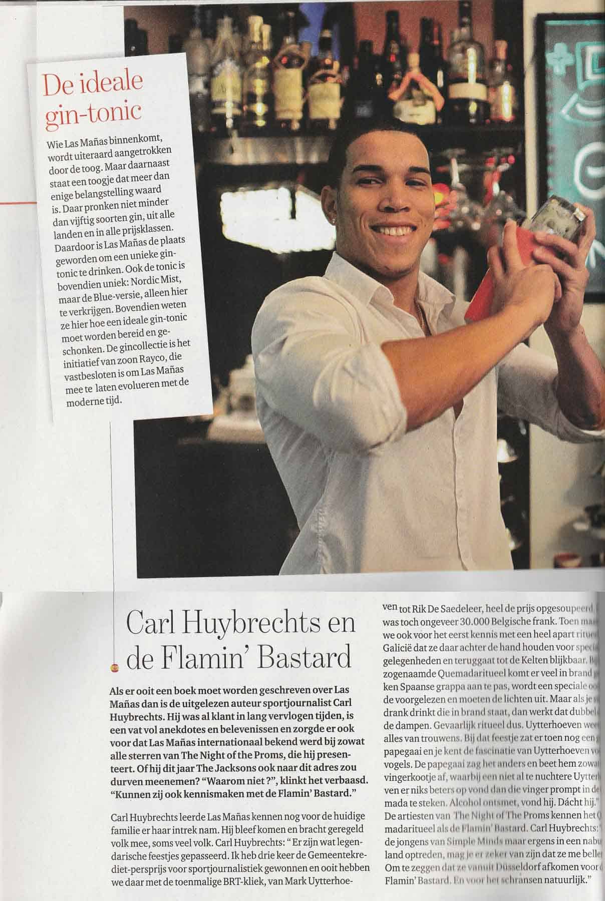 Gezicht van een jonge man die een exotische cocktail maakt in een moderne bar met diverse drankflessen op de achtergrond.