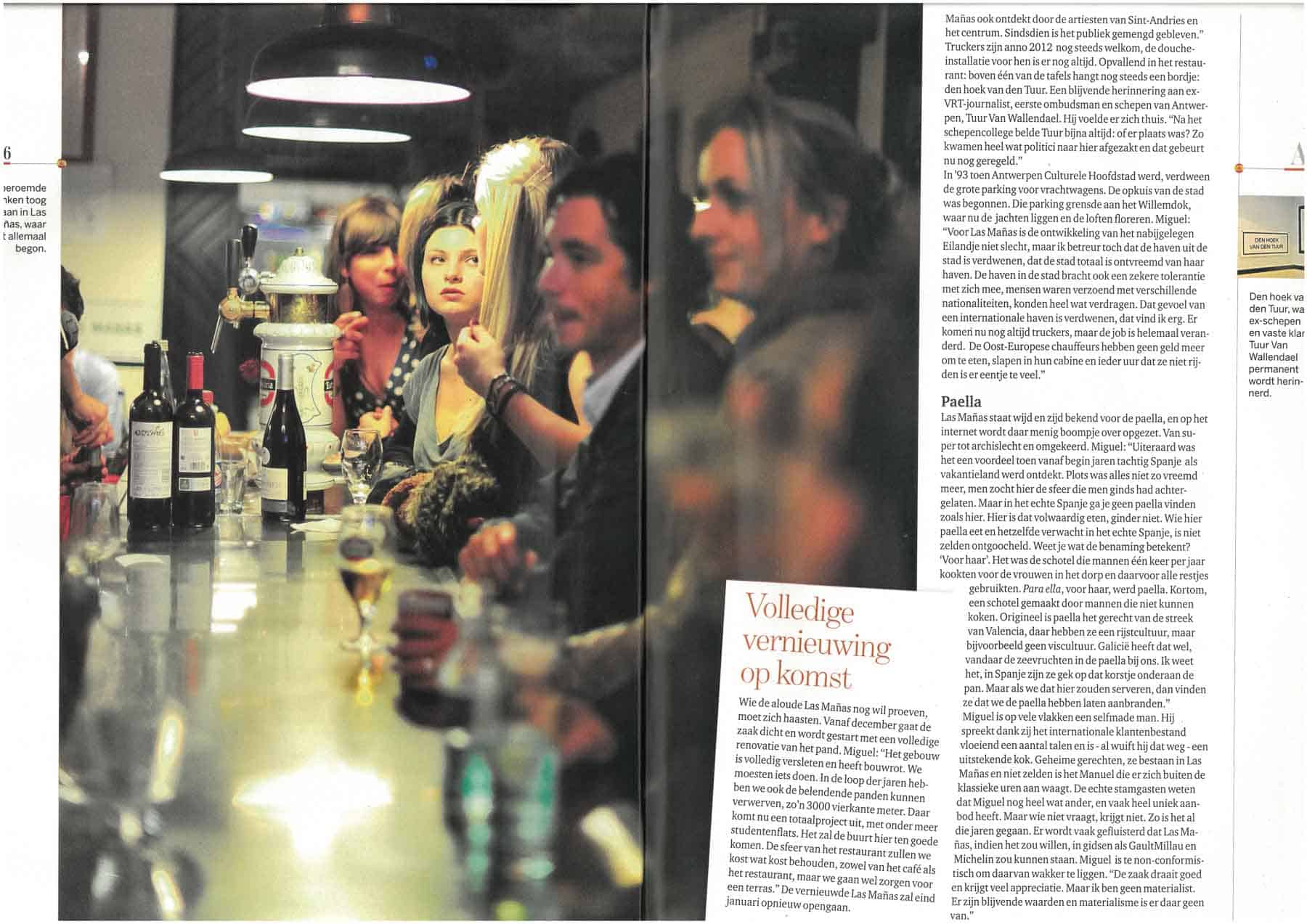 Acogedor bar en Amberes con diversos clientes que disfrutan del vino y la conversación, un interior atmosférico y un ambiente relajado en Las Mañas.
